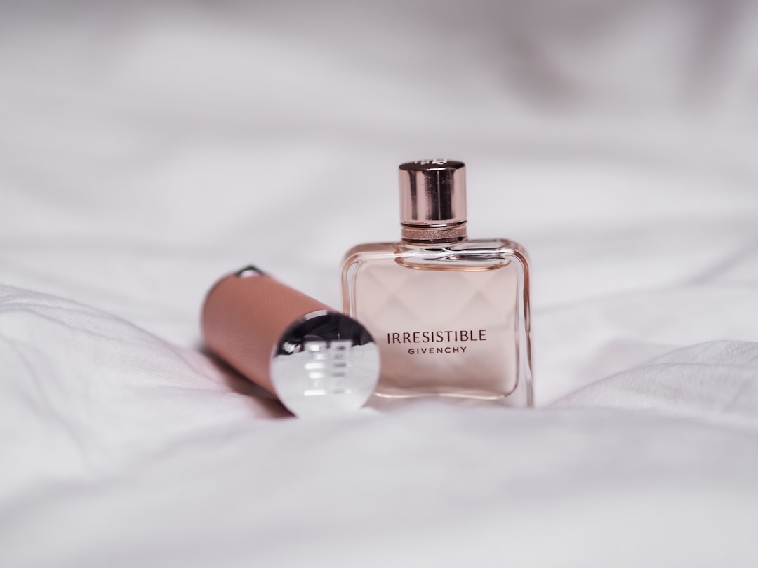 A person applying perfume in a serene setting, showcasing different fragrance bottles.