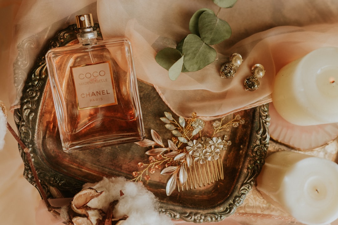A collection of perfume bottles representing different scent styles: fresh, floral, woody, and sweet, arranged aesthetically on a wooden surface.