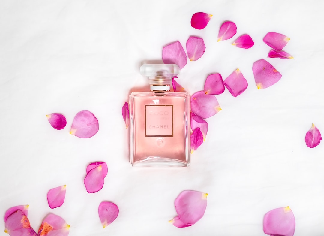 A beautifully arranged display of various feminine perfume bottles with elegant designs, set against a soft, neutral background.