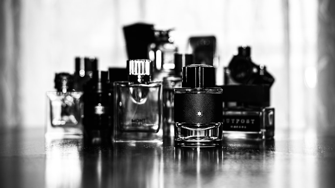 A man testing different colognes in a fragrance shop, surrounded by various perfume bottles.