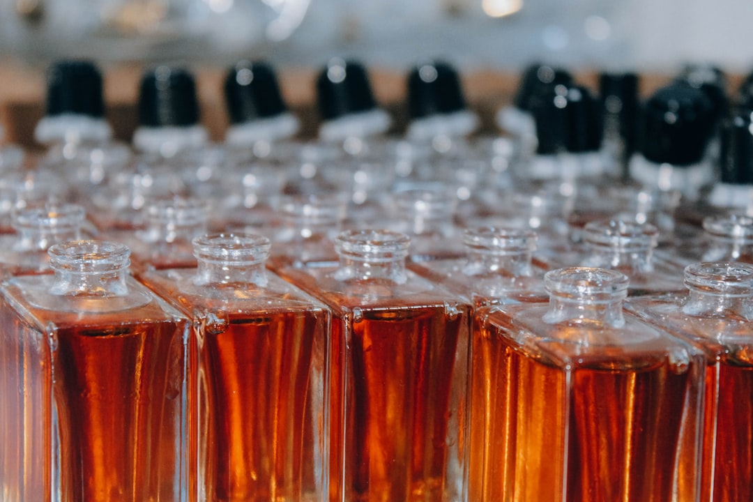 A beautifully arranged display of various perfume bottles on a shelf, showcasing different shapes and colors, with soft lighting to enhance their elegance.