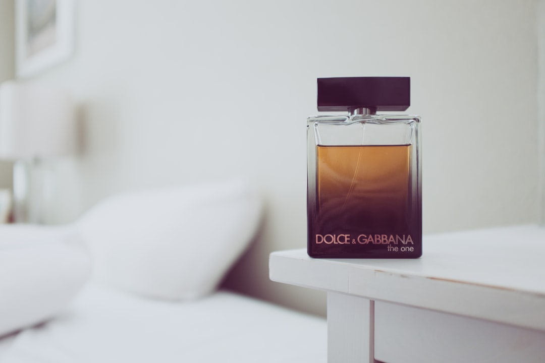 A close-up of two elegant fragrance bottles, one labeled perfume and the other labeled cologne, set against a soft, blurred background.
