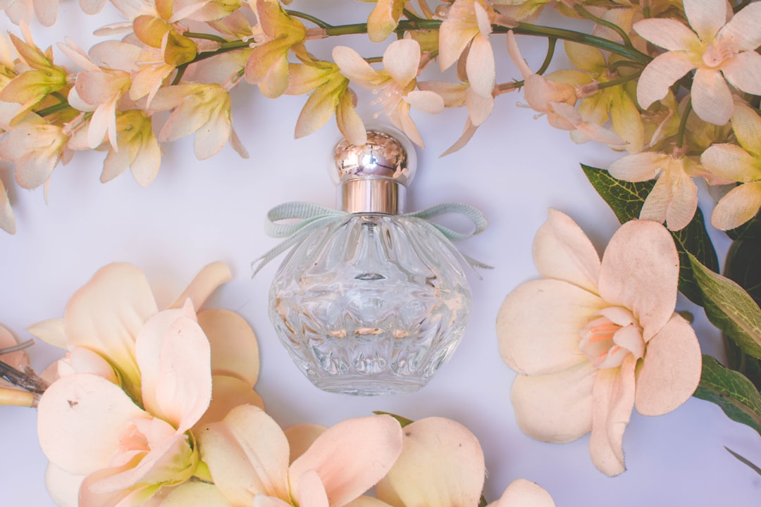 An elegant perfume bottle with intricate design, surrounded by soft fabric and flowers, conveying a sense of luxury and sophistication.
